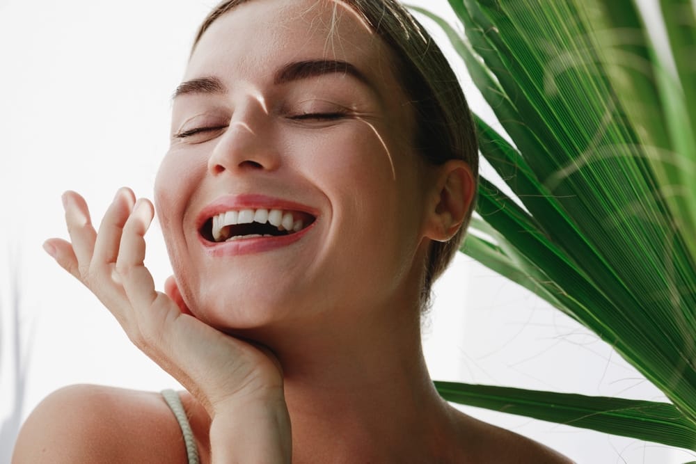 woman posing for a photo near a plant