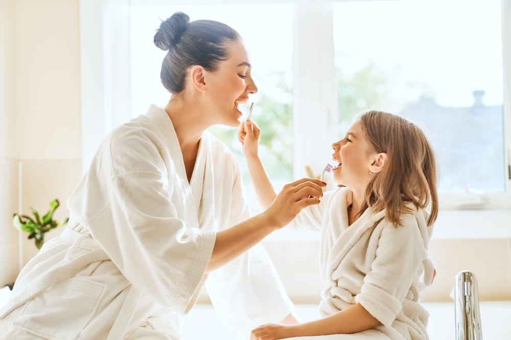 mother and daughter brushing teeth