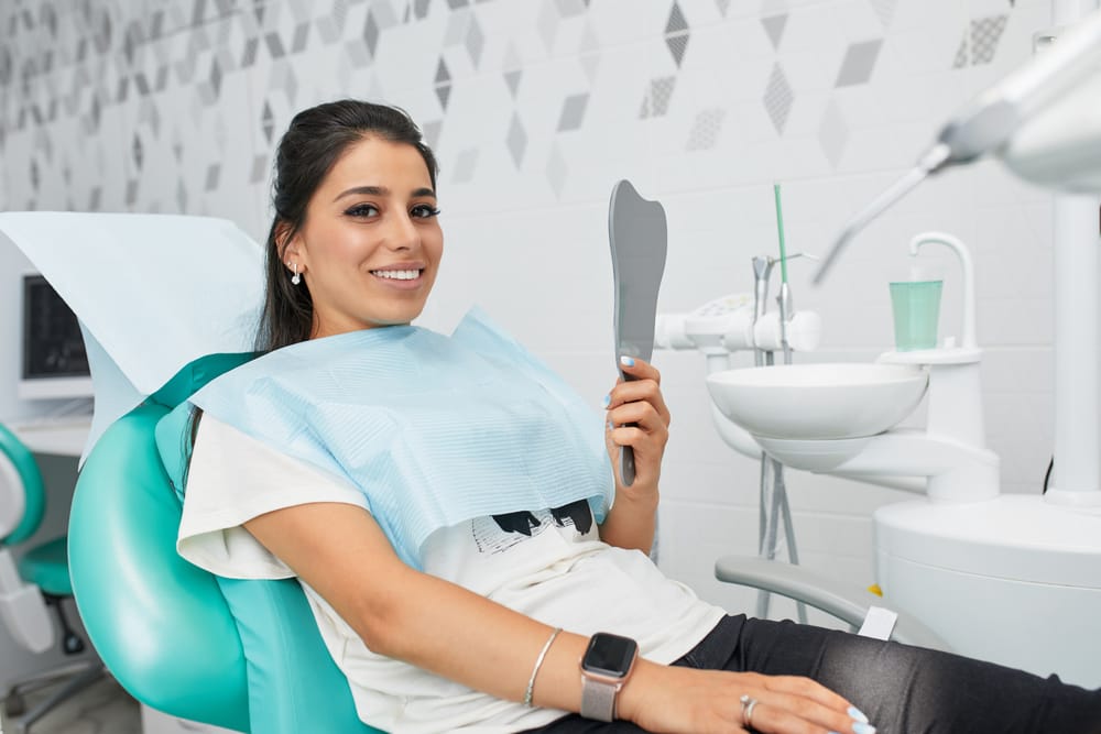beautiful woman holding a mirror at the dentist