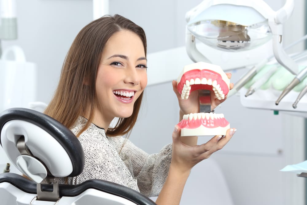 woman at the dentist holding teeth model - Orlando Root Canals