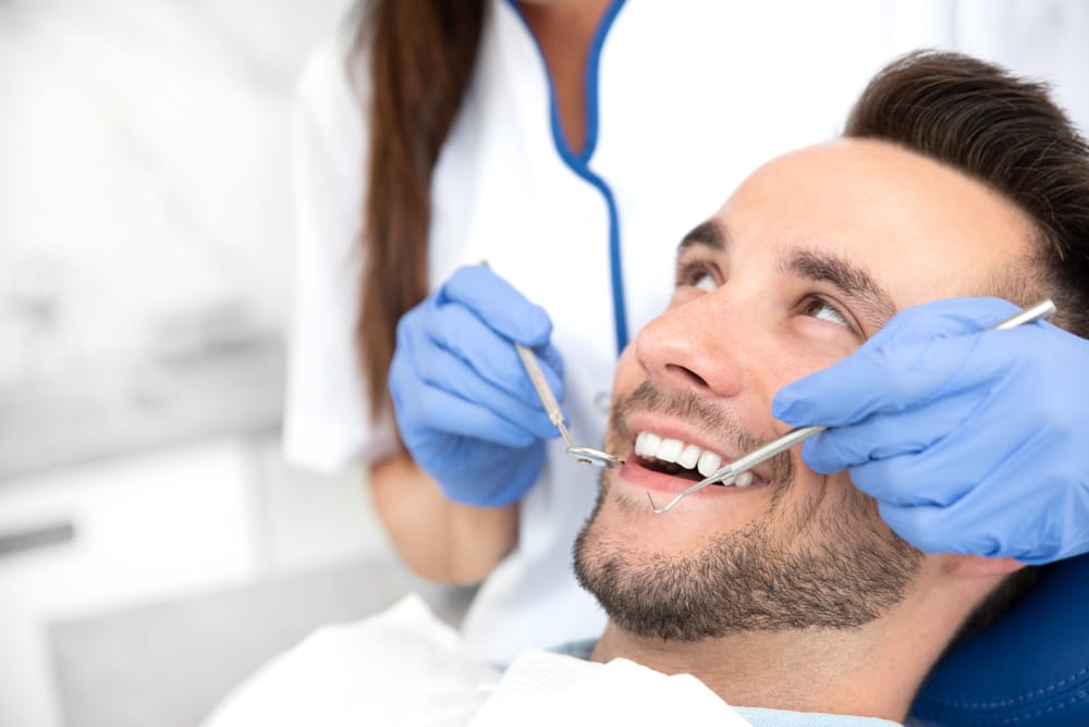 A dentist carefully examines a patient’s smile during a teeth whitening session, emphasizing precision, comfort, and cosmetic dental excellence in Orlando – Teeth Whitening Orlando.