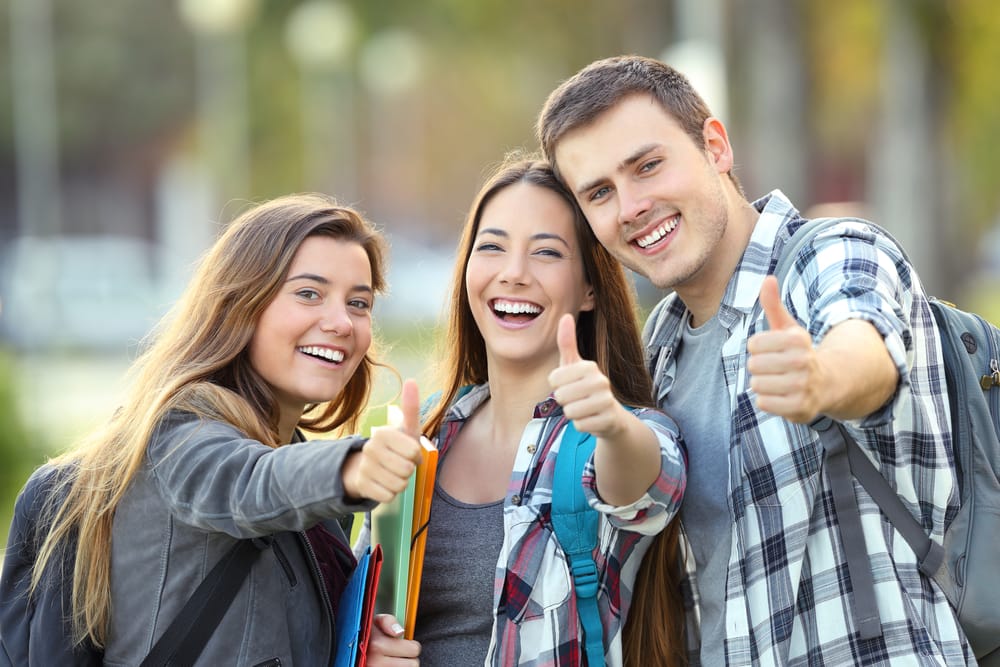 college students doing a thumbs up - Dental Implants Winter Park