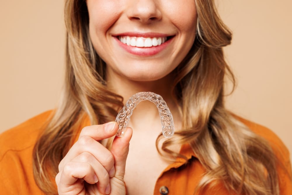 woman holding clear aligners