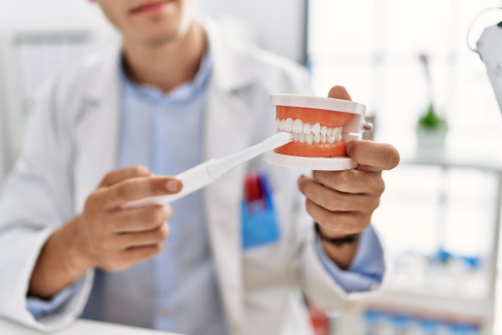 dentist showing how to brush teeth