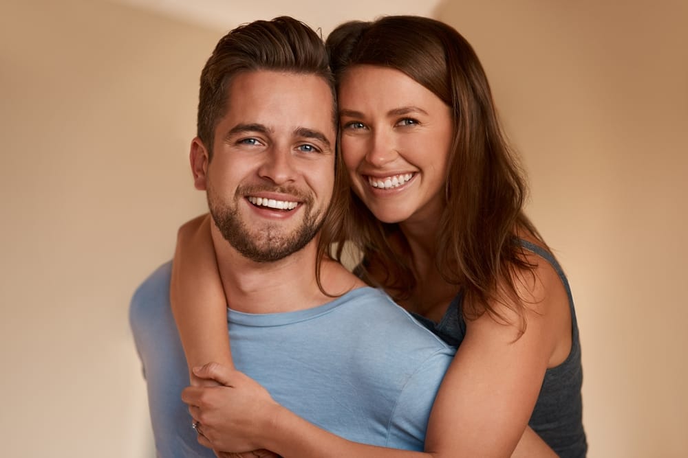 couple hugging and smiling for a photo - Dental Crowns Orlando