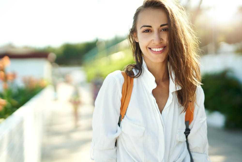 brown haired woman wearing a backpack outdoors