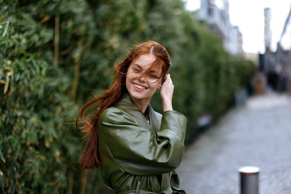 Red head woman posing for a photo outdoors - Teeth Whitening in Kissimmee