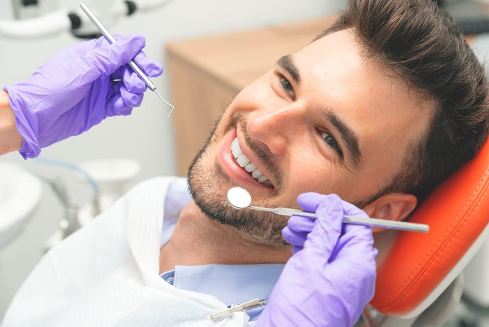 bearded man having a dental check up - Teeth Whitening in Kissimmee