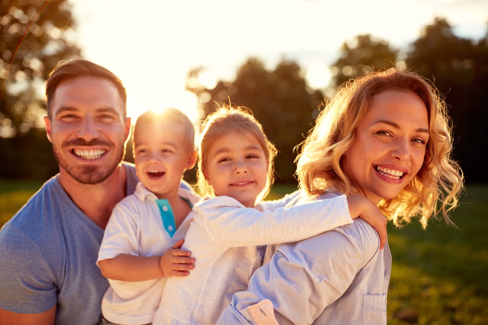 Happy family playing outdoors - Teeth Whitening in Kissimmee